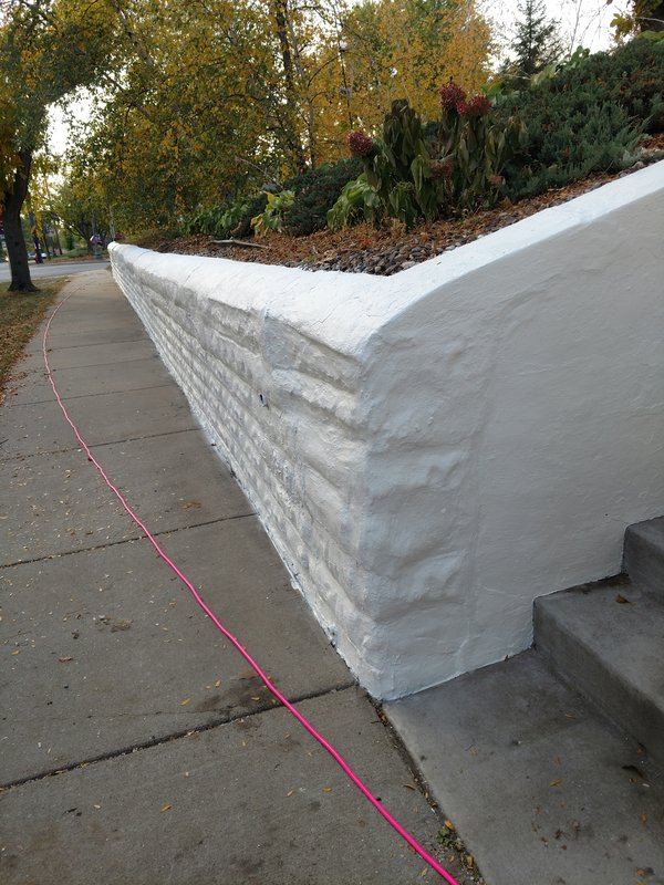 Finished curved retaining wall along sidewalk